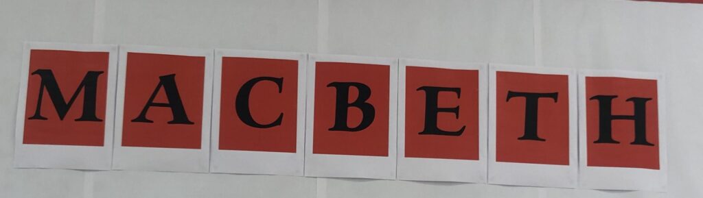 Macbeth spelt out - black letters on Red Cards.